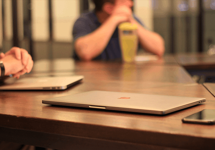 Apple product laptops sitting on a desk during an Apple IT consultancy meeting.